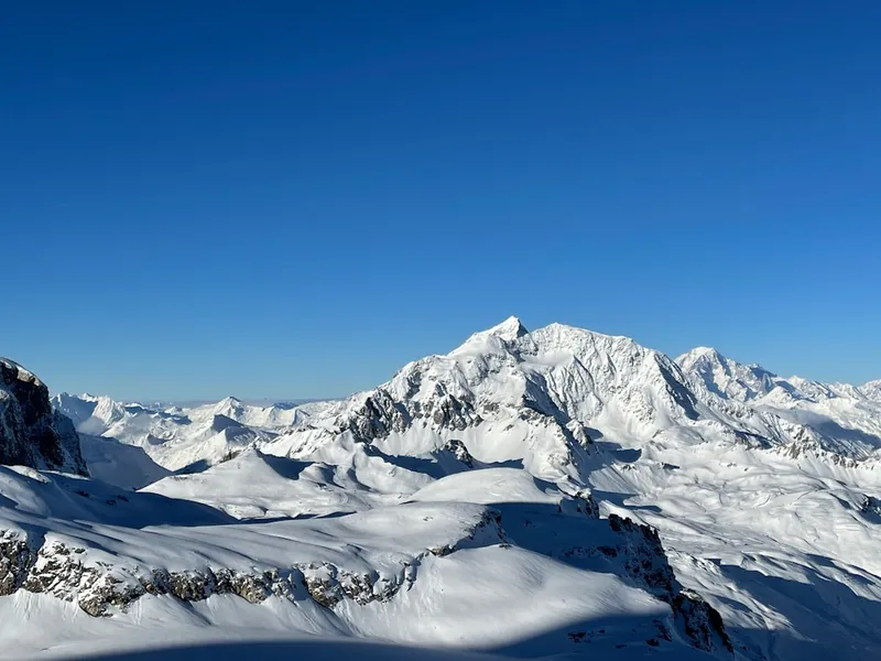 Snow-covered mountains under a clear blue sky